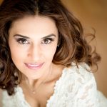 woman looking up at camera, smiling.