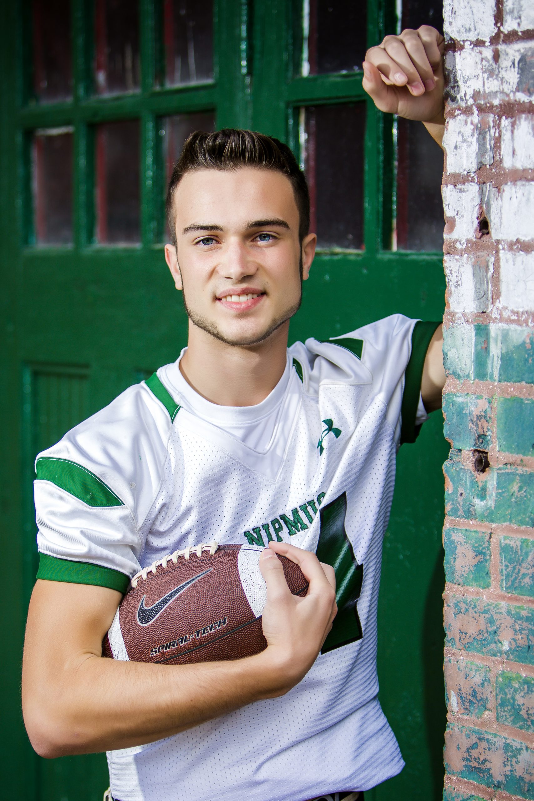 HS Boy wearing football jersey & holding football